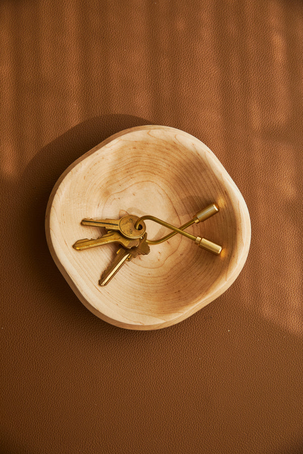 Wooden bowl with keys on a brown background