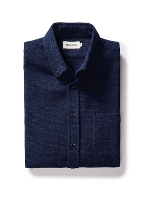 Folded navy blue shirt with a label on a white background