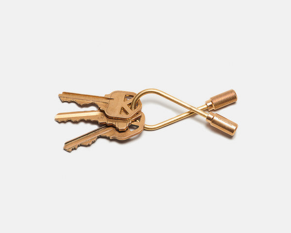 Gold keychain with keys on a white background