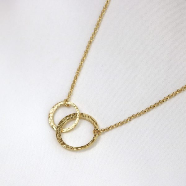 Gold necklace with interlocking rings on a white background
