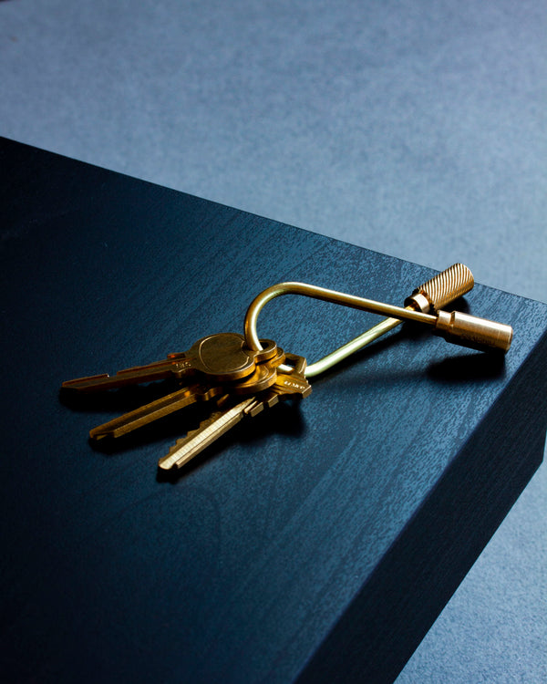 Gold keychain with keys on a dark surface