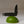 Black pocket knife balanced on a green lime against a neutral background