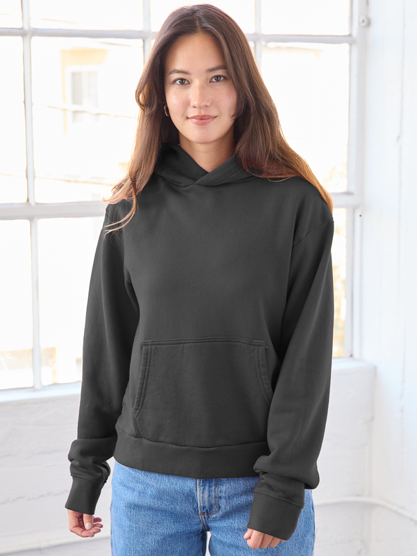 Person wearing a black hoodie with a neutral background
