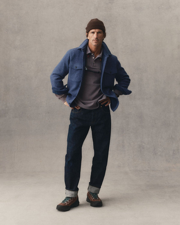 fit model with his hands on his arms wearing The Maritime Shirt Jacket in Heather Navy Wool