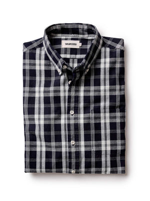 Folded dark navy and white checkered shirt on a white background
