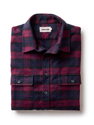 Folded plaid shirt with a visible brand label on a white background