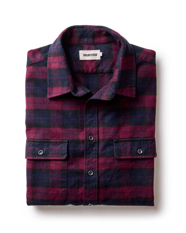 Folded plaid shirt with a visible brand label on a white background